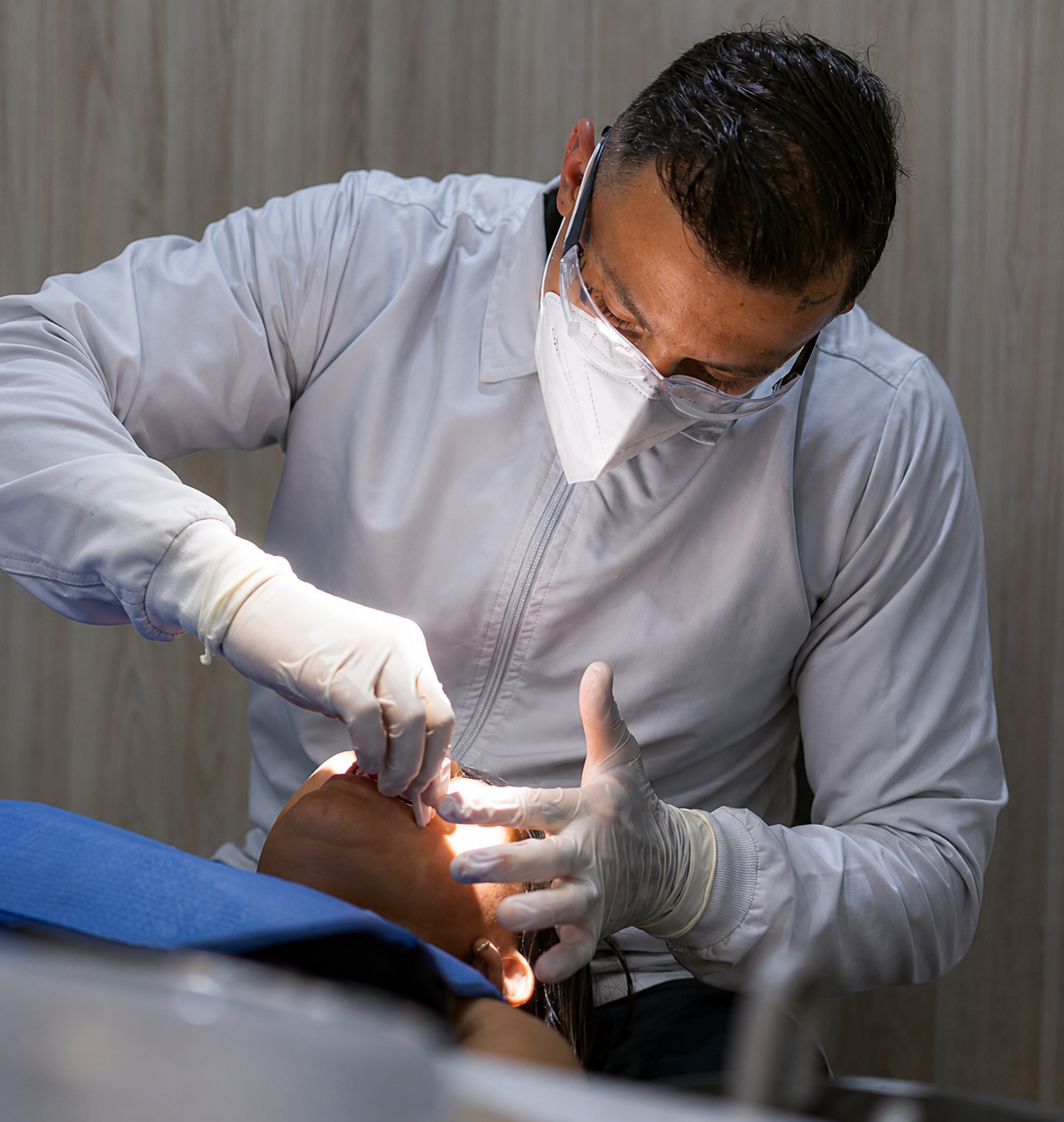 Dr. Cristian Valencia realizando procedimiento odontológico con tecnología avanzada en Armenia